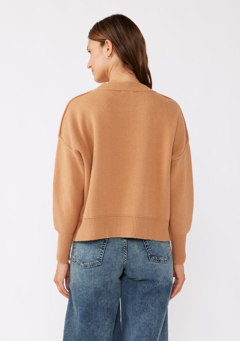 [Color: Camel] A brunette model wearing a solid brown, tan sweater crafted in a comfy knit with a relaxed, boxy silhouette. Featuring long sleeves with dropped shoulders, a crew neckline, and ribbed trims. Perfectly cozy and casual for everyday styling. 