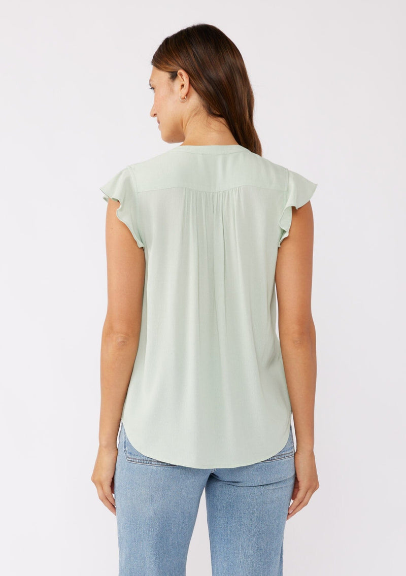 [Color: Mint] A brunette model wearing a classic Lovestitch button up top in green mint. With short flutter sleeves, split v neckline, and a floral lace trim at the yoke. Perfect for the summer and beyond.