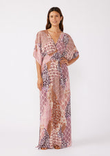 [Color: Natural/Clay] A blonde model wearing an ultra bohemian maxi dress in a pink patchwork print. Featuring flowy kimono sleeves, v neckline, smocked waist, a sexy open back with tie detail, and side slits. Perfect as a beach cover up or casual outings. 