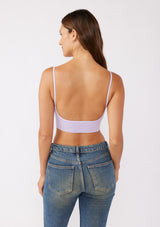 [Color: Lilac] A brunette model wearing a fitted crop lingerie top in purple. A casual yet stylish undergarment perfect for styling under dresses or wearing on it's own as a sports bra. A comfortable stretchy ribbed knit top with a low back and spaghetti straps.