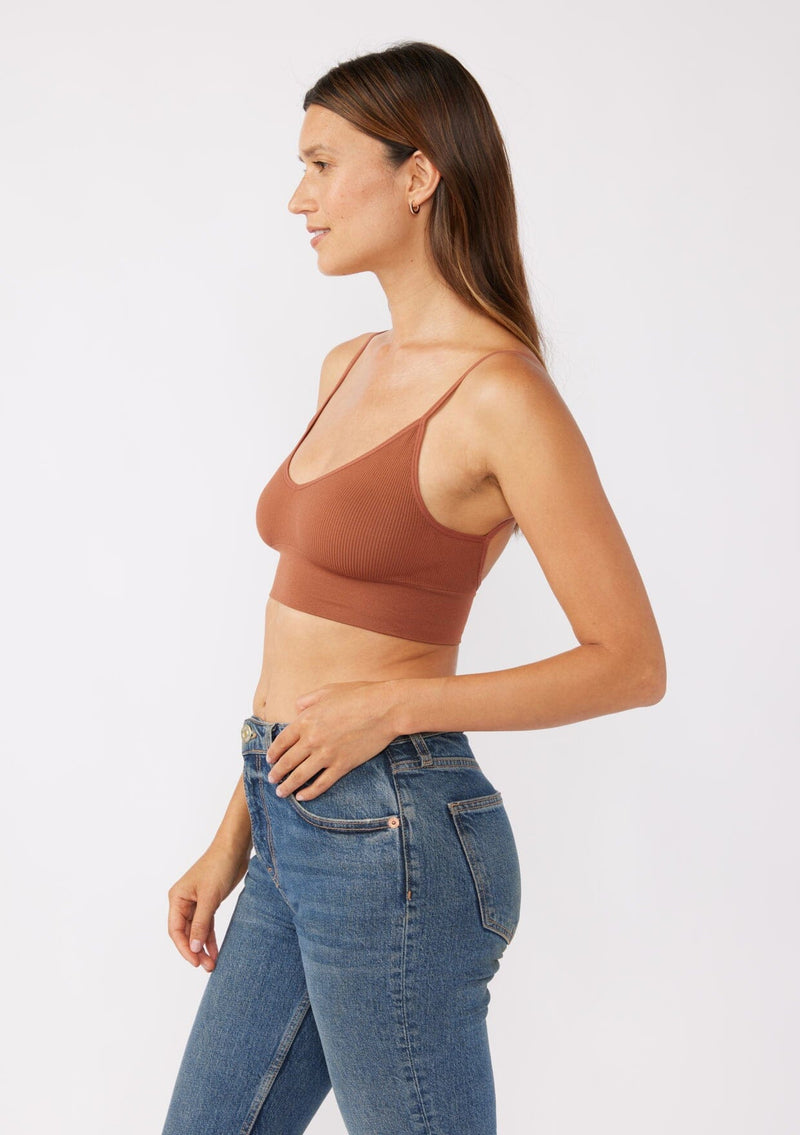 [Color: Chocolate] A brunette model wearing a fitted crop lingerie top in dark brown. A casual yet stylish undergarment perfect for styling under dresses or wearing on it's own as a sports bra. A comfortable stretchy ribbed knit top with a low back and spaghetti straps.