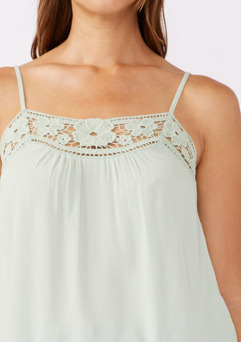 [Color: Mint] A detailed image of a brunette model wearing a green mint bohemian top with floral lace details. This sleeveless design features adjustable spaghetti straps, delicate lace trims, and a smocked back. Perfect for everyday styling.     