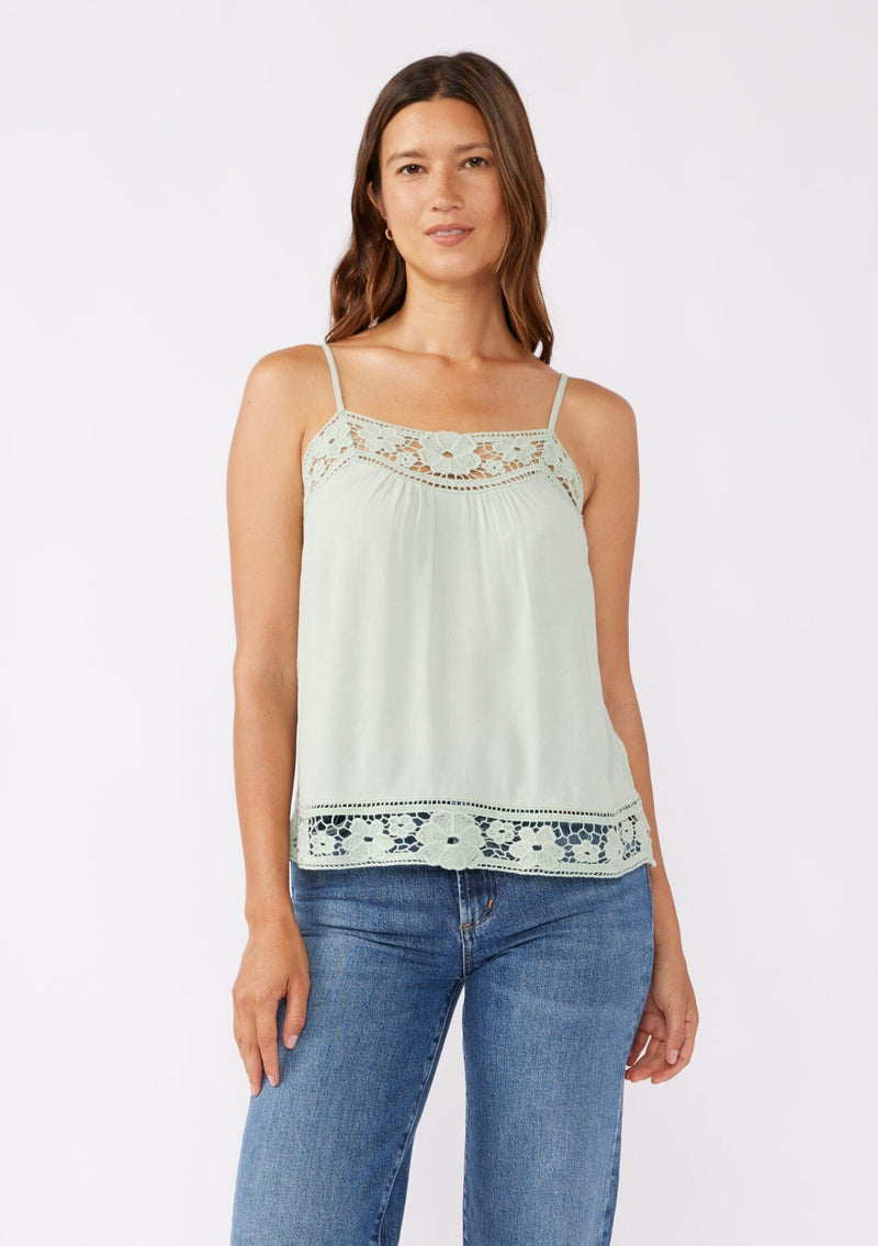 [Color: Mint] A front facing image of a brunette model wearing a green mint bohemian top with floral lace details. This sleeveless design features adjustable spaghetti straps, delicate lace trims, and a smocked back. Perfect for everyday styling.     