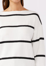 [Color: White/Black] A brunette model wearing a classic black and white striped knit pullover sweater. With long sleeves, a boat neckline, and ribbed trims. Perfectly relaxed and boxy for everyday styling. 