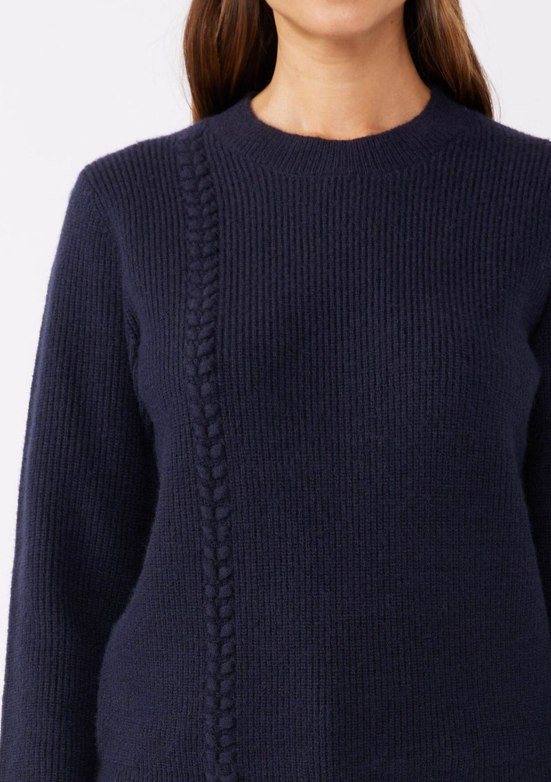 [Color: Navy] A brunette model wearing a classic crew neck sweater in navy blue. With ribbed trims, long sleeves, and a cable knit stitch detail. A versatile sweater perfect for layering during colder temperatures or wearing on its own. 