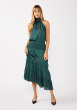 [Color: Teal] A full body front facing image of a blonde model wearing a green holiday halter maxi dress with a sleeveless design, smocked drop waist, and a tiered skirt. This flowy satin dress is perfect for any special occasion and holiday events. 