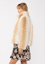 [Color: Natural] A side facing image of a blonde model wearing a tan brown stripe, dotted fur faux coat over a floral dress. Featuring a high collar, open front, and long sleeves. A cold weather style, perfect for any special occasion. 