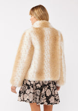 [Color: Natural] A back facing image of a blonde model wearing a tan brown stripe, dotted fur faux coat over a floral dress. Featuring a high collar, open front, and long sleeves. A cold weather style, perfect for any special occasion. 