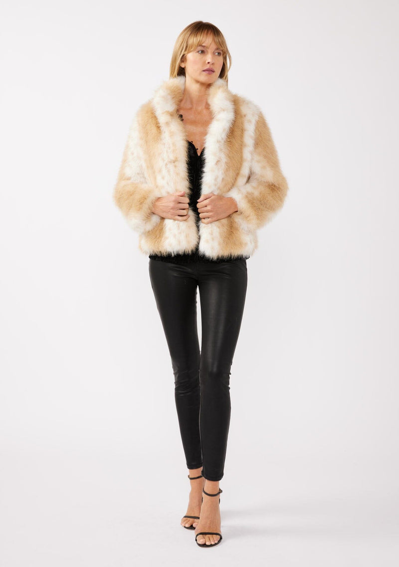 [Color: Natural] A front facing image of a blonde model wearing a tan brown stripe, dotted fur faux coat with an all black outfit. Featuring a high collar, open front, and long sleeves. A cold weather style, perfect for any special occasion. 