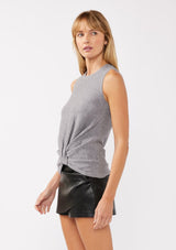 [Color: Dark Heather Grey] A side facing image of a blonde model wearing a cozy grey sweater tank top with a ribbed texture, twisted front hemline and a round neckline. A relaxed casual top for the spring season. 