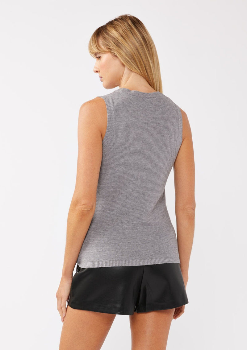 [Color: Dark Heather Grey] A back facing image of a blonde model wearing a cozy grey sweater tank top with a ribbed texture, twisted front hemline and a round neckline. A relaxed casual top for the spring season. 