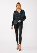 [Color: Midnight/Black] A full body front facing image of a blonde model wearing a leopard print blouse in black and blue. With a split v-neckline, smocked cuffs, and a smocked back detail. Ultra relaxed and flowy, perfect work and special occasions. 