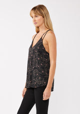 [Color: Black/Rose] A model wearing a black and pink floral tank top with racerback detail, a v neckline, and a strappy tie neck. This relaxed fit tank top is perfect for the office or casual laid back days. 