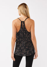 [Color: Black/Rose] A model wearing a black and pink floral tank top with racerback detail, a v neckline, and a strappy tie neck. This relaxed fit tank top is perfect for the office or casual laid back days. 