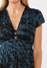 [Color: Midnight/Black] A detail image of a blonde model wearing a black and blue leopard print maxi dress. With a deep v neckline, short sleeves, elastic waistline, and side slits. A versatile holiday dress, perfect for casual outings and special occasions. 