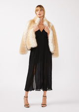 [Color: Black] A blonde model wearing a sleeveless, pleated maxi dress with a fur coat. This special occasion dress features a surplice v neckline, empire waistline, an adjustable strappy back, and a side slit. Perfect for the holidays or any special event. 