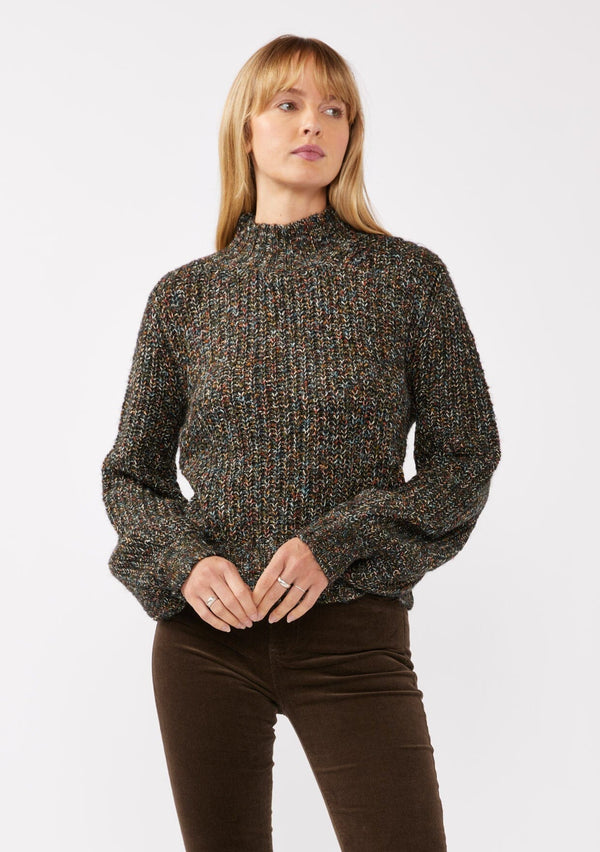 [Color: Black Multi] A front facing image of a blonde model wearing a chunky multi color knit sweater with a mock neckline and long voluminous sleeves. 