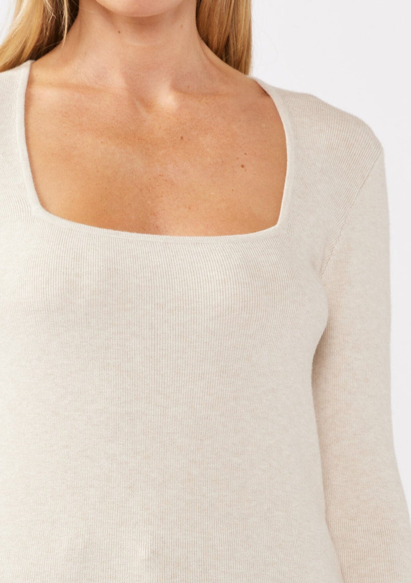 [Color: Heather Stone] A detail image of a blonde model wearing a classic body hugging pullover sweater in off white. With a classic square neckline, long sleeves, and a straight hem. Styled with corduroy bottoms for a laid-back cool girl fall ensemble.   