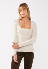 [Color: Heather Stone] A blonde model wearing a classic body hugging pullover sweater in off white. With a classic square neckline, long sleeves, and a straight hem. Styled with corduroy bottoms for a laid-back cool girl fall ensemble.   