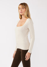 [Color: Heather Stone] A blonde model wearing a classic body hugging pullover sweater in off white. With a classic square neckline, long sleeves, and a straight hem. Styled with corduroy bottoms for a laid-back cool girl fall ensemble.   