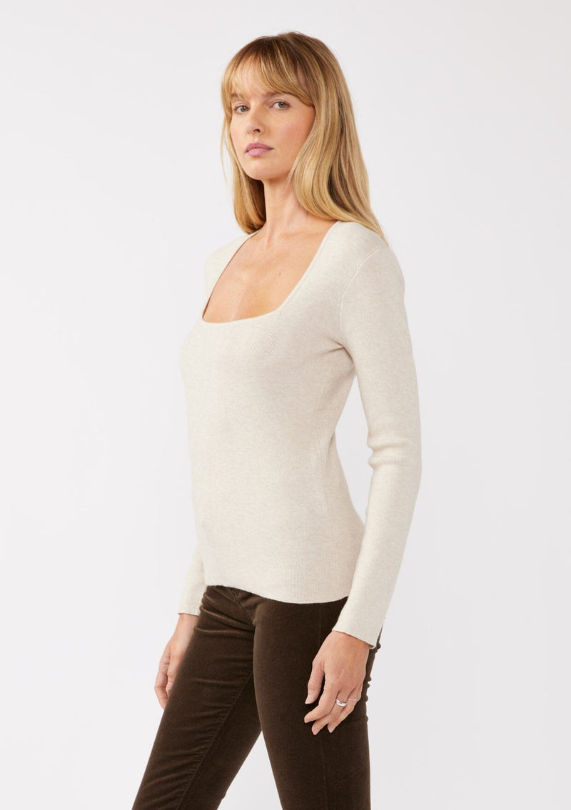 [Color: Heather Stone] A blonde model wearing a classic body hugging pullover sweater in off white. With a classic square neckline, long sleeves, and a straight hem. Styled with corduroy bottoms for a laid-back cool girl fall ensemble.   