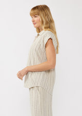 [Color: Natural/Black] A side facing image of a blonde model wearing a beige camp shirt in a cotton blend with a black yarn-dye stripe pattern, featuring a collared neckline, short dolman sleeves, and button-front closure—ideal for lounging, vacation days, or resort styling.