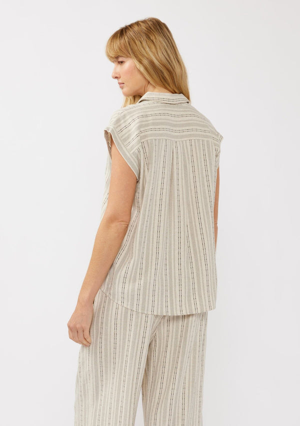 [Color: Natural/Black] A side facing image of a blonde model wearing a beige camp shirt in a cotton blend with a black yarn-dye stripe pattern, featuring a collared neckline, short dolman sleeves, and button-front closure—ideal for lounging, vacation days, or resort styling.