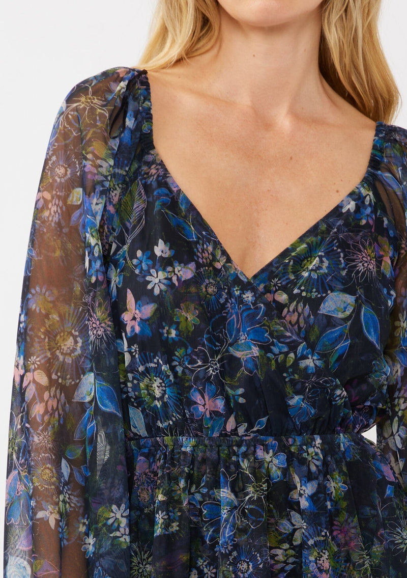 [Color: Black/Dusty Pink] A detail image of a blonde model wearing a blue floral print mini dress crafted in a lightweight micro mesh fabric. With a surplice v-neckline, long sleeves, elastic faux wrap waist, and elastic shoulders. Perfect for evening dinners and weddings. 