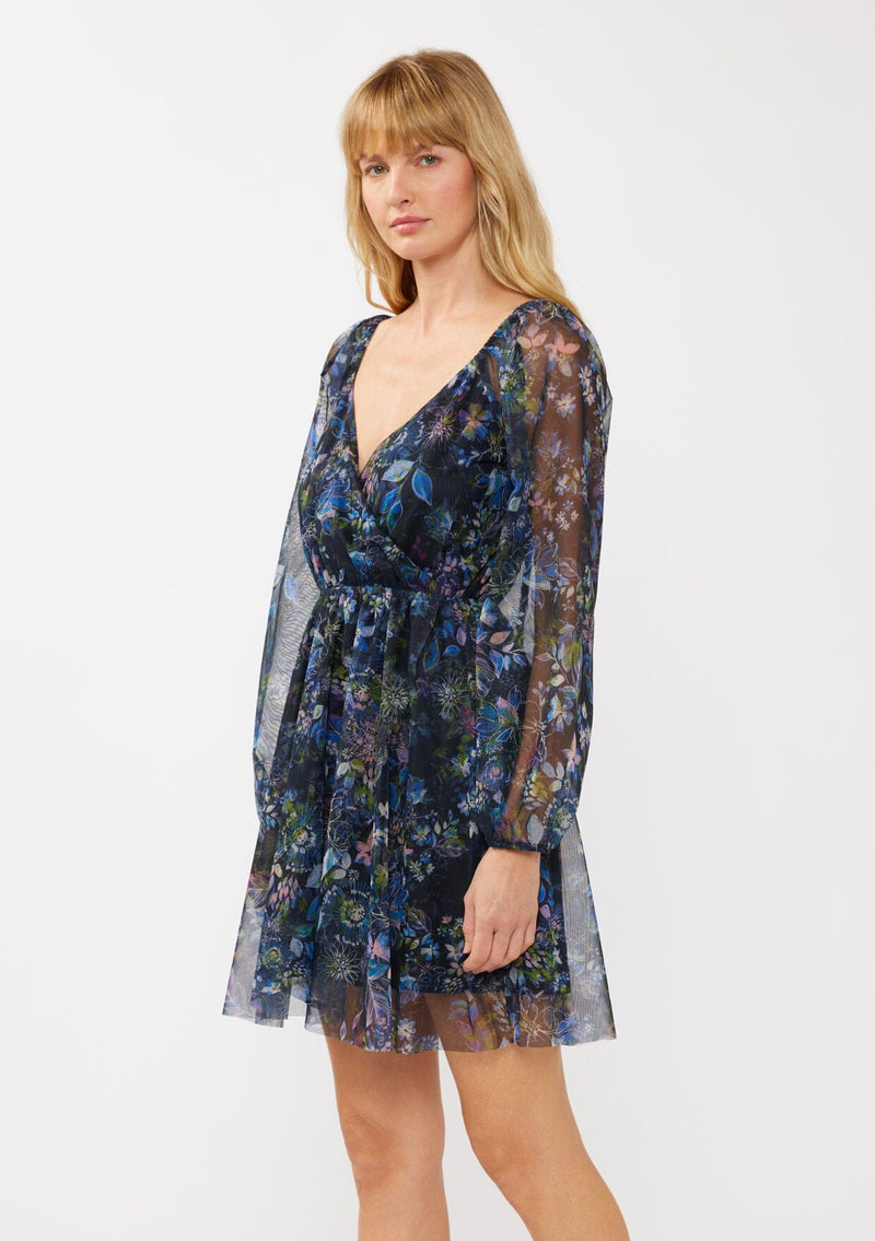 [Color: Black/Dusty Pink] A side facing image of a blonde model wearing a blue floral print mini dress crafted in a lightweight micro mesh fabric. With a surplice v-neckline, long sleeves, elastic faux wrap waist, and elastic shoulders. Perfect for evening dinners and weddings. 