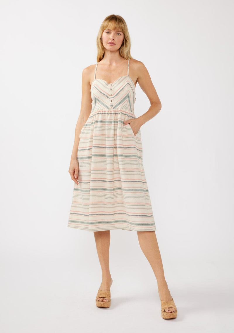 [Color: Natural/Multi] A blonde model wearing a striped yarn-dye midi dress made from lightweight, airy cotton. The dress features a fitted bodice with button details, a smocked back, a full skirt, and side pockets—perfect for casual special occasions.