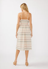 [Color: Natural/Multi] A blonde model wearing a striped yarn-dye midi dress made from lightweight, airy cotton. The dress features a fitted bodice with button details, a smocked back, a full skirt, and side pockets—perfect for casual special occasions.