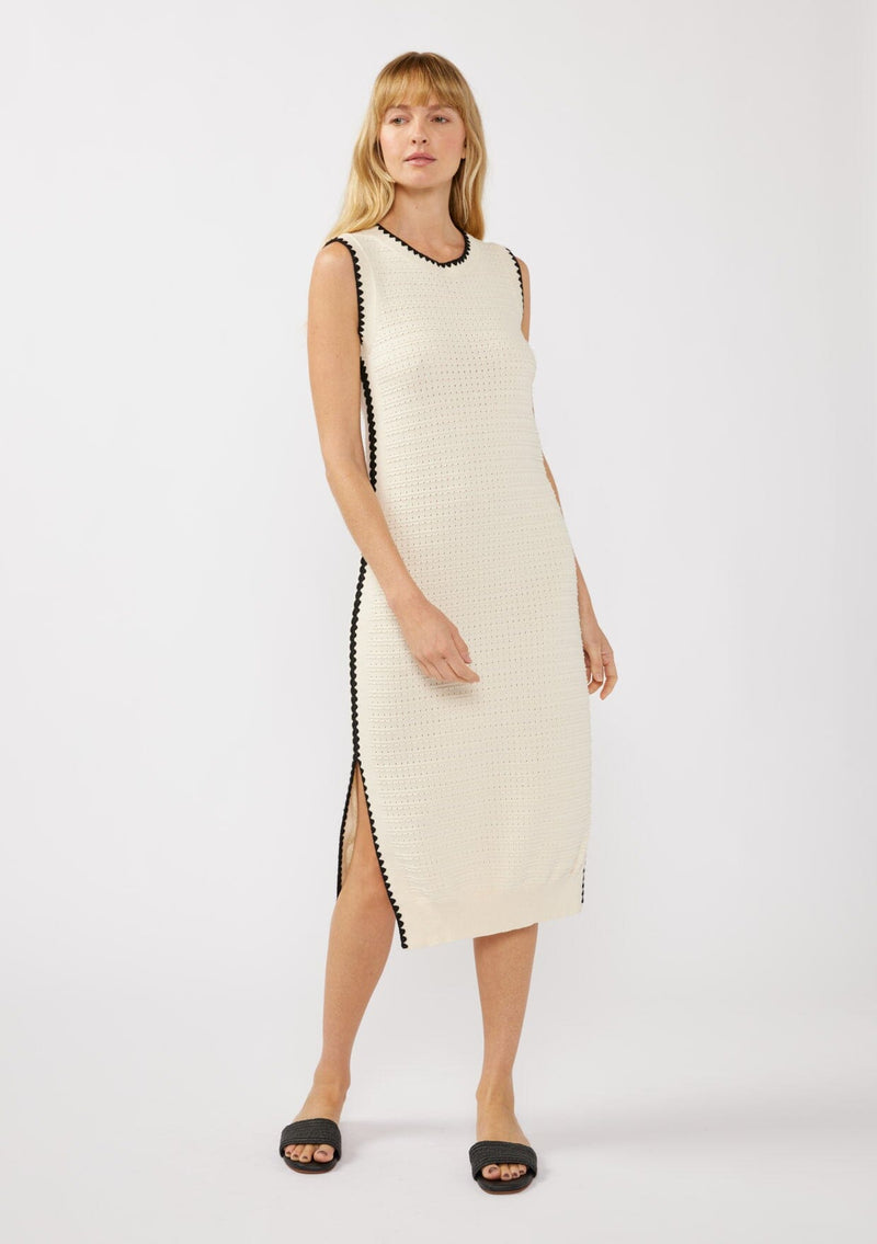 [Color: Natural/Black] A front facing image of a blonde model wearing an off white tank midi dress crafted in a stripe knit texture with a round neckline, side slits, and a black contrast stitch trim. A casual throw-on for vacation, resort styling, and lounging. 