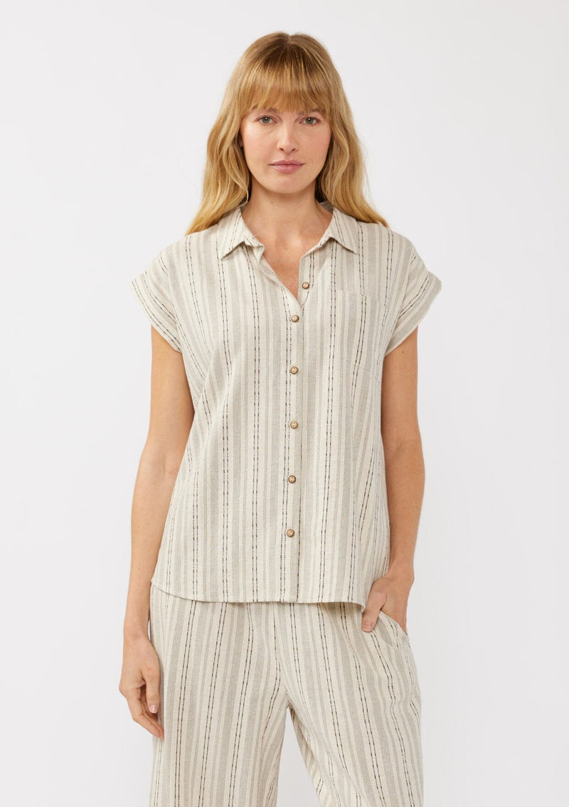 [Color: Natural/Black] A front facing image of a blonde model wearing a beige camp shirt in a cotton blend with a black yarn-dye stripe pattern, featuring a collared neckline, short dolman sleeves, and button-front closure—ideal for lounging, vacation days, or resort styling.