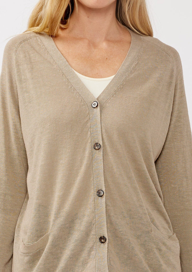 [Color: Taupe] A detail image of a blonde model wearing a thin linen and viscose blend cardigan with long sleeves, a button front, and a v-neckline. An effortless basic throw on cardigan for the spring season. 