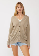 [Color: Taupe] A front facing image of a blonde model wearing a thin linen and viscose blend cardigan with long sleeves, a button front, and a v-neckline. An effortless basic throw on cardigan for the spring season. 