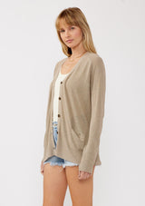 [Color: Taupe] A side facing image of a blonde model wearing a thin linen and viscose blend cardigan with long sleeves, a button front, and a v-neckline. An effortless basic throw on cardigan for the spring season. 