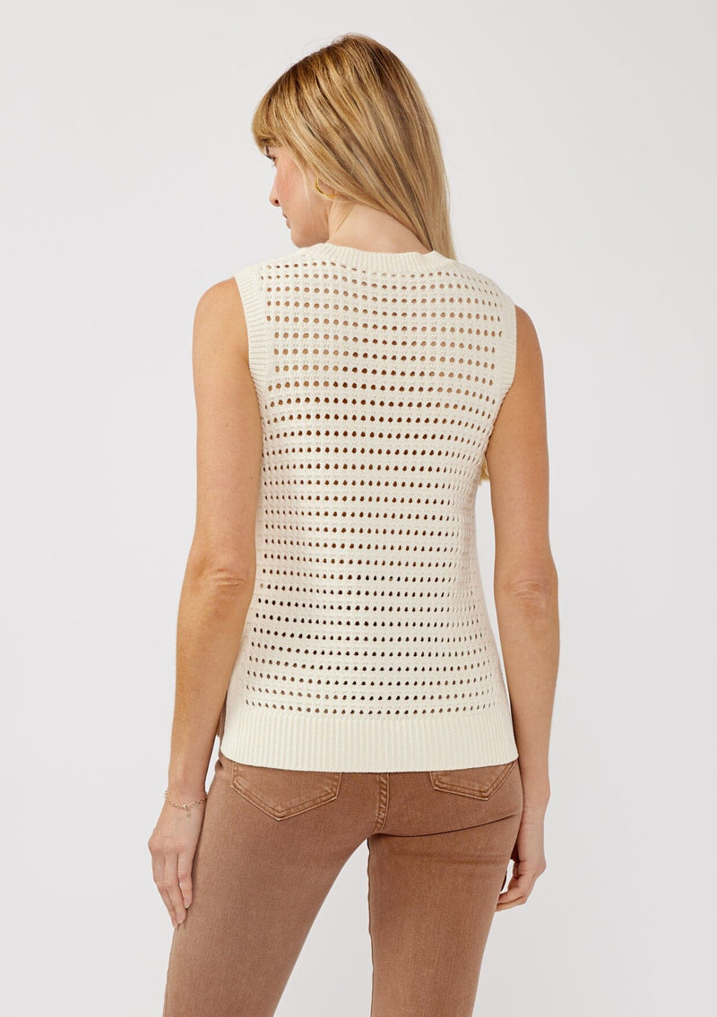 [Color: Ivory] A back facing image of a blonde model wearing an ivory sleeveless open knit sweater vest with a crew neckline, ribbed trim, and side slits. Perfect for layering over long sleeves or wearing on its own. 