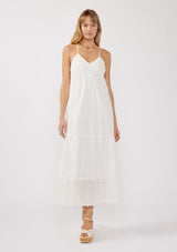 [Color: White] A front image of a blonde model wearing a bohemian-inspired white maxi dress featuring embroidered eyelet details and textured clip dots. The relaxed, tiered silhouette includes adjustable straps, a v-neckline, and a racerback design, making it ideal for beach days, weddings, or any special occasion.