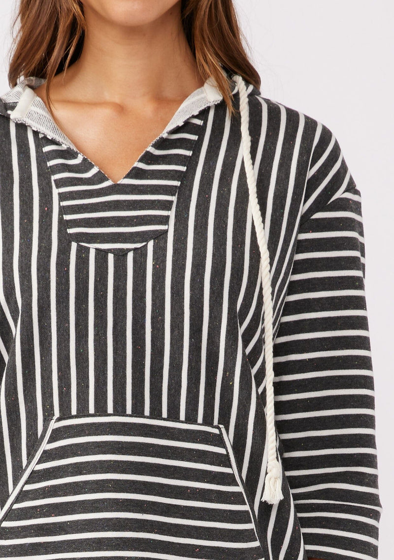 [Color: Black] A brunette model wearing a striped hoodie pullover in black with white stripes. Featuring 3/4 length sleeves, v-neckline, and a kangaroo pocket. A casual beach throw on that can be worn over a swimsuit or ripped denim cut offs. 