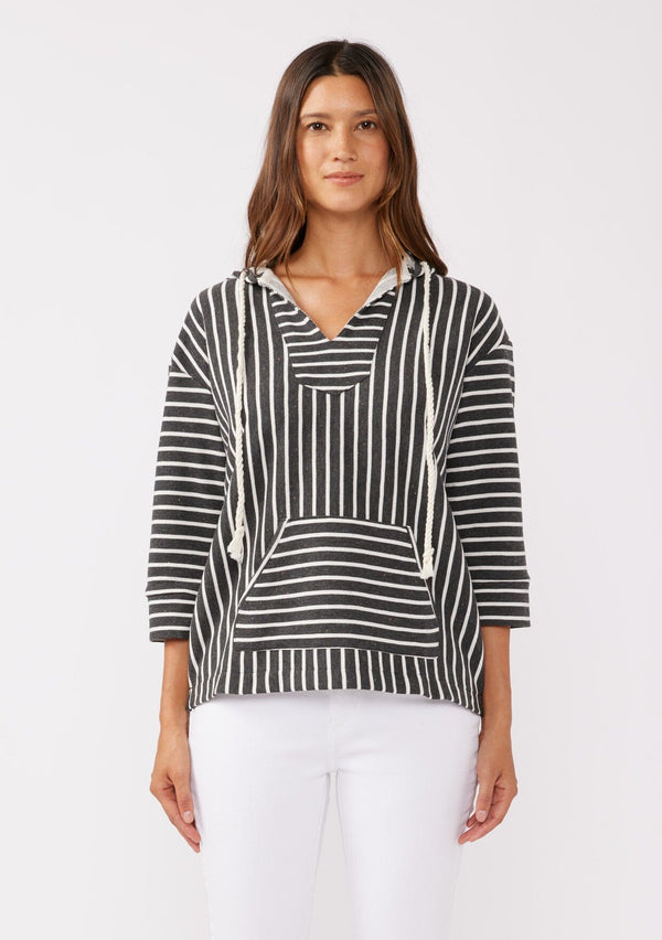 [Color: Black] A brunette model wearing a striped hoodie pullover in black with white stripes. Featuring 3/4 length sleeves, v-neckline, and a kangaroo pocket. A casual beach throw on that can be worn over a swimsuit or ripped denim cut offs. 