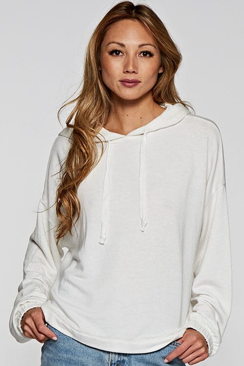 [Color: Off White]  A blonde model wearing a solid white pullover hoodie with a drawstring hood, long sleeves, and dropped shoulders. The cropped length makes it perfect for lounging, travel, or casual fall outings.