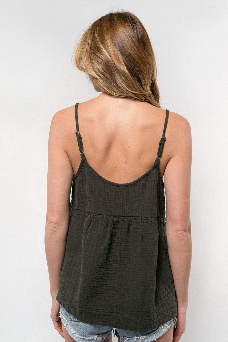 [Color: Evergreen] A blonde model wearing a forest green lightweight, cotton gauze tank top with skinny adjustable straps, a scoop neckline, and a relaxed fit. 