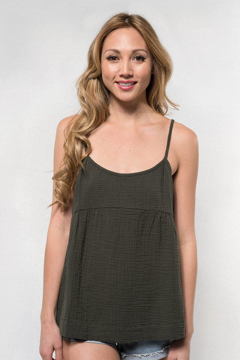 [Color: Evergreen] A blonde model wearing a forest green lightweight, cotton gauze tank top with skinny adjustable straps, a scoop neckline, and a relaxed fit. 