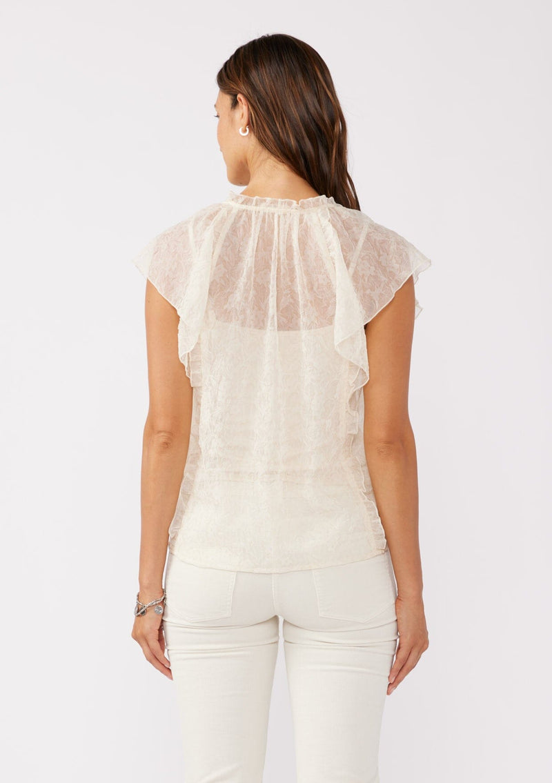 [Color: Ivory] A back facing image of brunette model wearing a crinkled chiffon top with a floral pattern. This ivory off white top features a sheer flowy silhouette, flutter short sleeves, split v neckline with ties, and ruffled details with a merrow edge finish.  