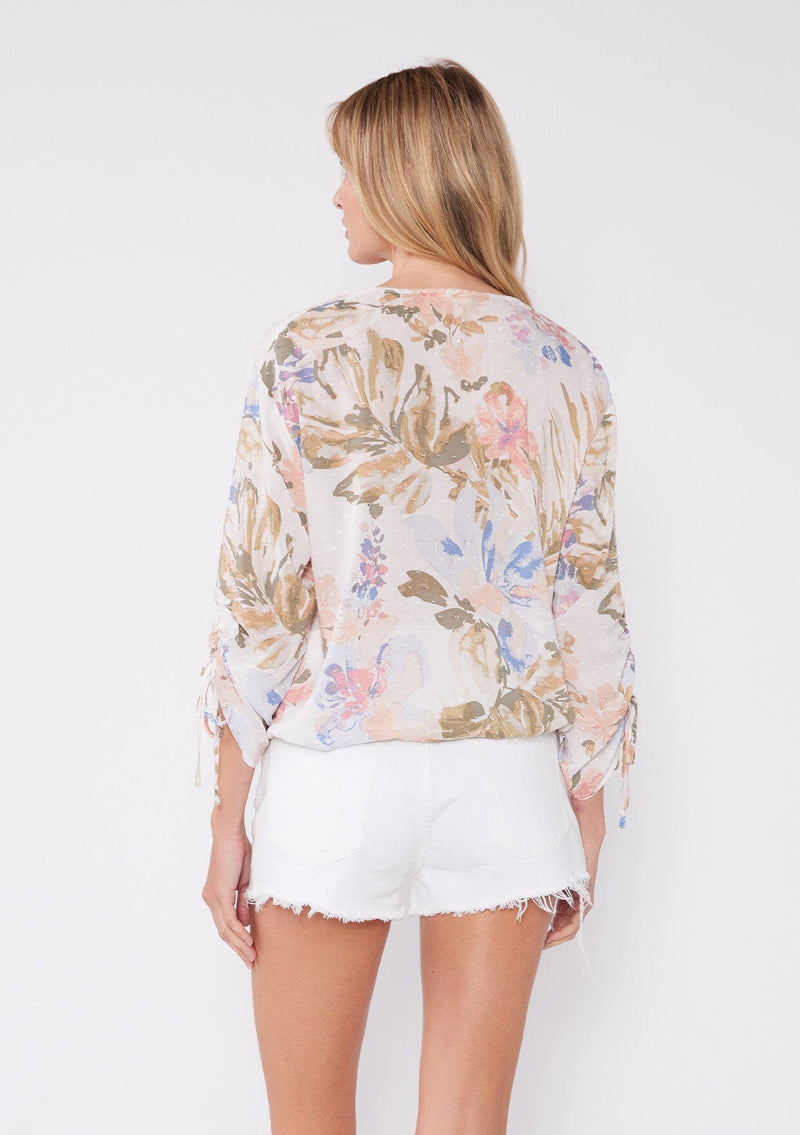 [Color: Off White/Periwinkle] Women's floral summer blouse with a surplice v neckline, front hook and eye closure, ruched three quarter sleeves, and front elastic hem for comfort. A casual floral top paired with white shorts for vacation.