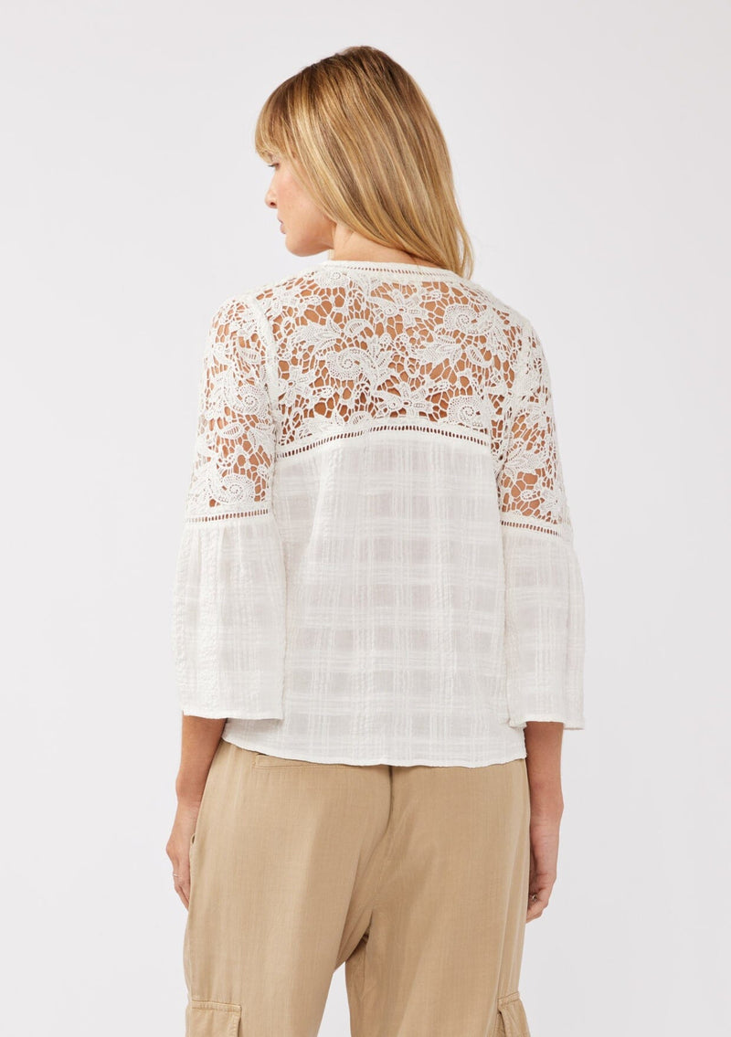 [Color: Off White] A back facing image of a blonde model wearing a textured seersucker plaid top with a lace contrast yoke. With a v-neckline, button front, long bell sleeves, and a tie front detail at the hem. A resort top perfect for pairing with denim shorts or any relaxed bottom. 