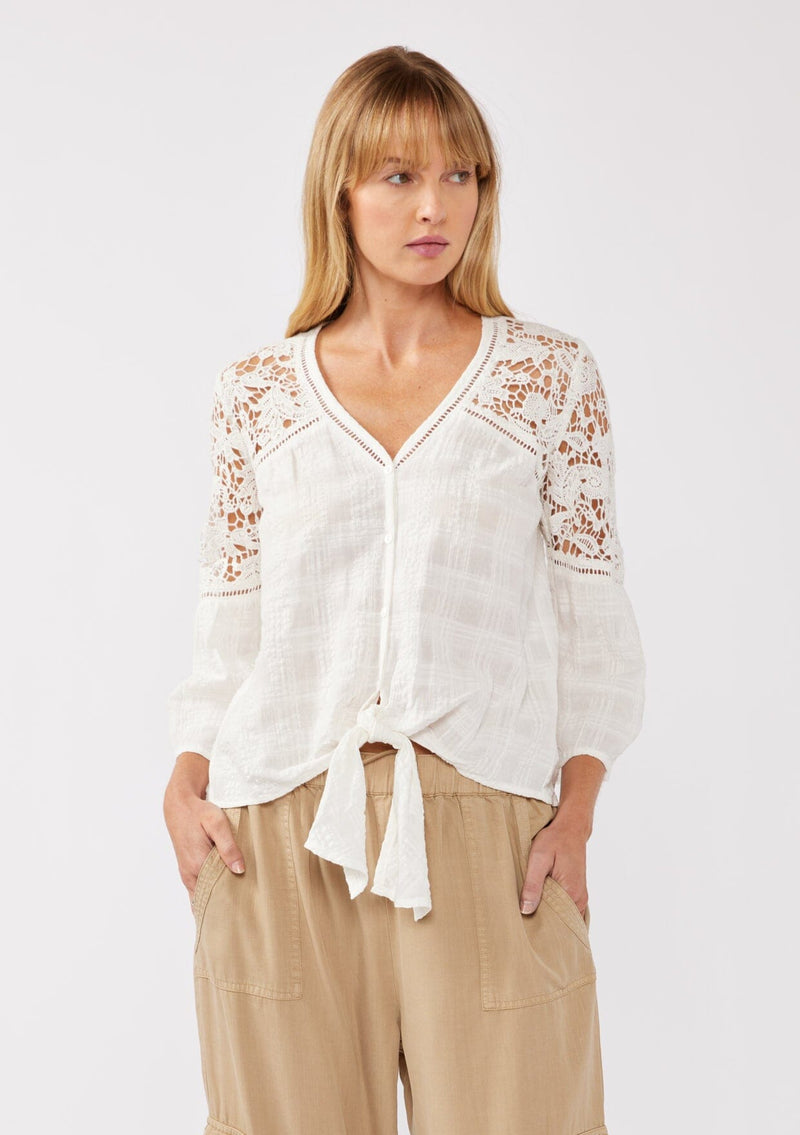 [Color: Off White] A front facing image of a blonde model wearing a textured seersucker plaid top with a lace contrast yoke. With a v-neckline, button front, long bell sleeves, and a tie front detail at the hem. A resort top perfect for pairing with denim shorts or any relaxed bottom. 