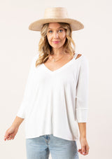 [Color: White] A blonde model wearing an ultra soft bamboo knit tee. This micro rib top features 3/4 length sleeves, a v-neckline, and cutout shoulder details. A basic essential for any season. 