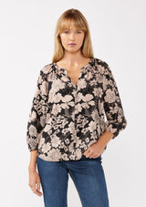 [Color: Black/Taupe] A front facing image of a blonde model wearing a black and taupe floral print blouse. This boho casual blouse features a self covered button front, a split v-neckline, and 3/4 length sleeves. Perfect for any casual outing or vacation. 