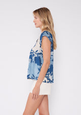 [Color: Navy/Dusty Blue] Bohemian summer top featuring short cap sleeves, a split v neckline, gathered details at the yoke, and a raw edge hem. The light blue and white tropical floral print gives endless summer vacation vibes.